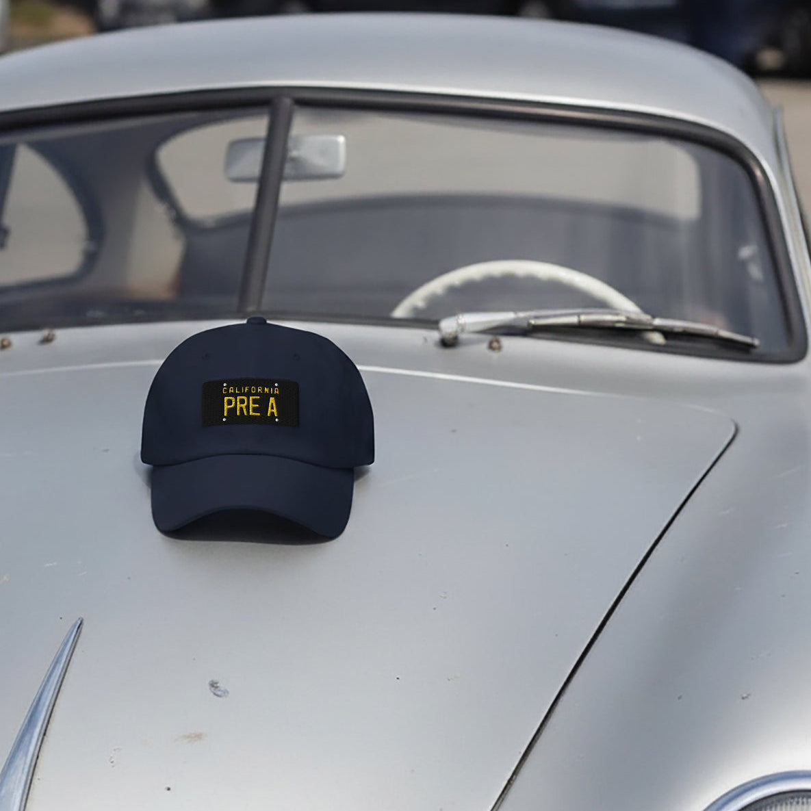 Navy blue California PRE A Porsche Baseball cap on the hood of a Patina Pre A 356 Porsche.