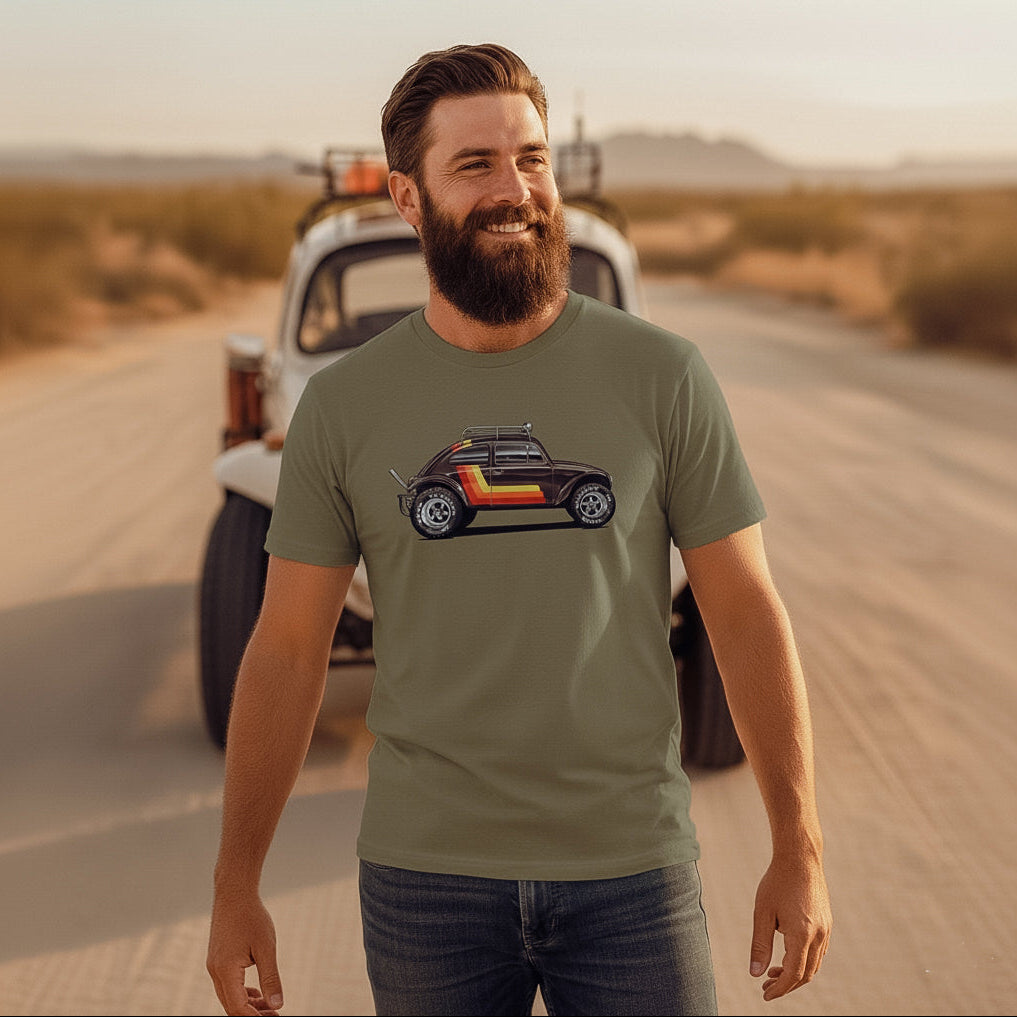 Man standing in a desert with a vintage Baja bug in the background, wearing a 'Stripes' Baja Bug T-shirt.