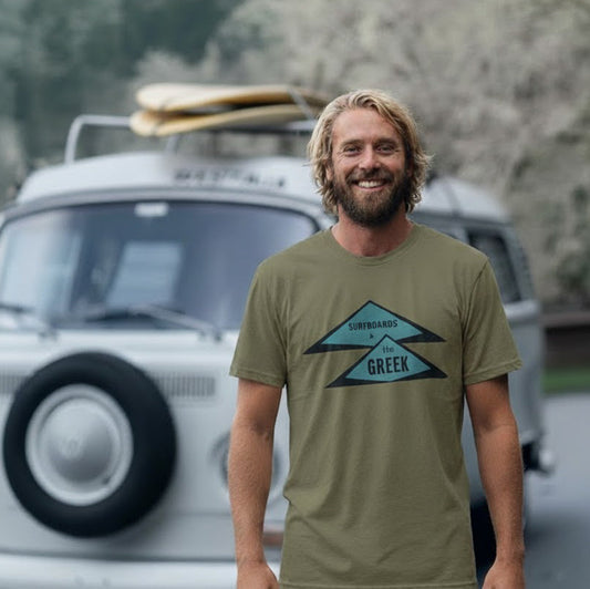 Man stands in front of a VW Camper Bus wearing a Vintage style Surfboards by The Greek Khaki T-shirt.