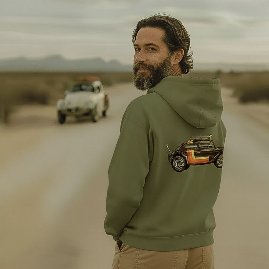Man wearing a green 'Stripes' Baja Bug hoodie in a desert setting with a Baja Bug in the background.