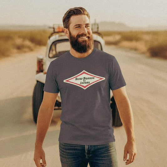 Man stands in front of a VW Baja Bug wearing a Vintage style Surfboards by Jacobs dark grey T-shirt.