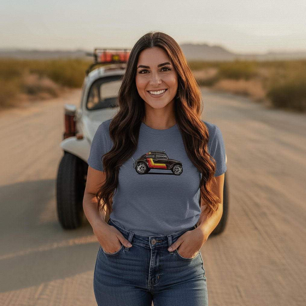 Woman standing in a desert with a vintage Baja bug in the background, wearing a 'Stripes' Baja Bug T-shirt.